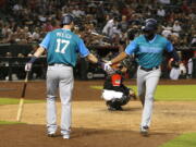 Seattle Mariners’ Denard Span celebrates with Mitch Haniger (17) after hitting a solo home run against the Arizona Diamondbacks during the 10th inning of a baseball game Saturday, Aug. 25, 2018, in Phoenix.