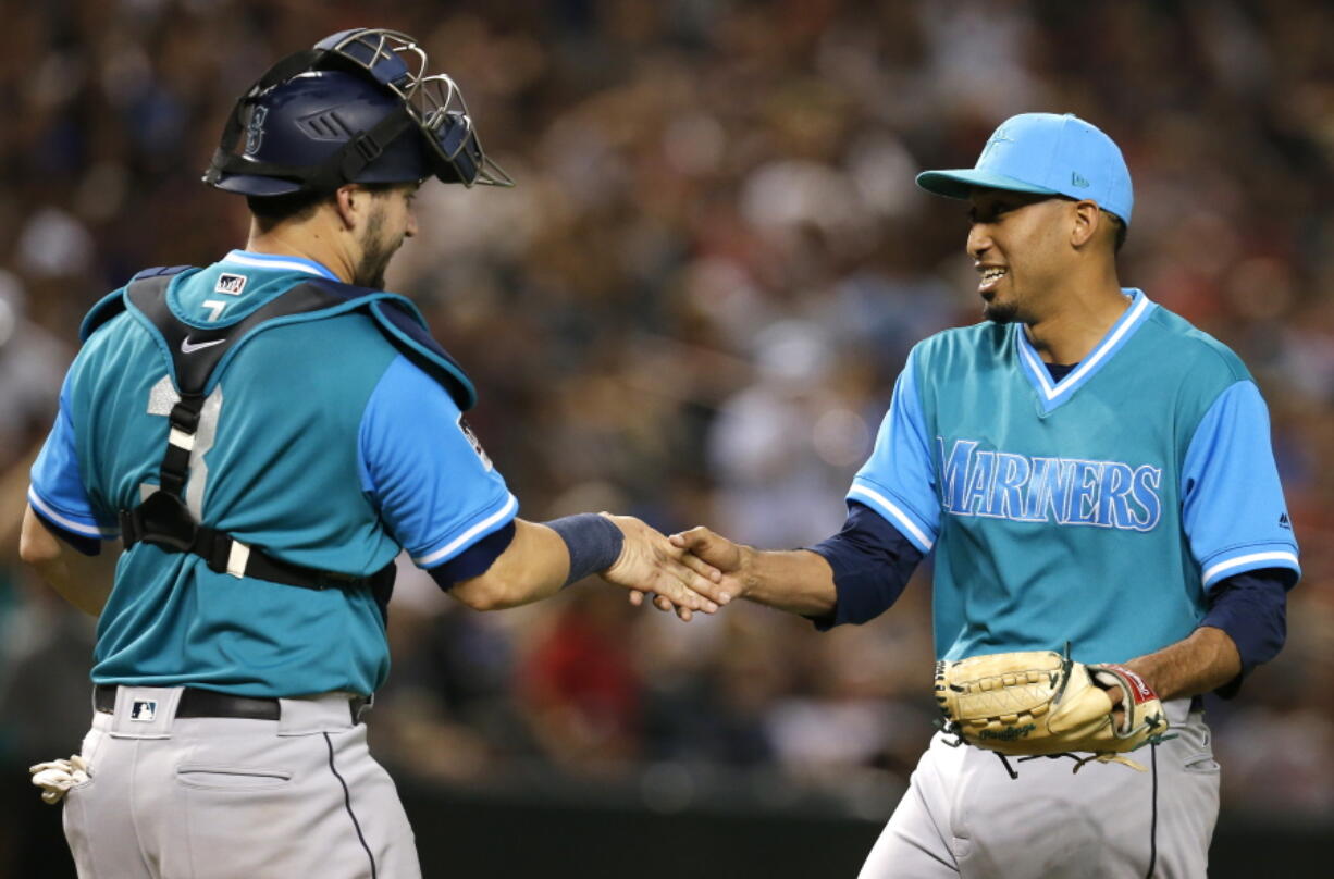 Seattle Mariners catcher Mike Zunino (3) and Edwin Diaz celebrate after the Mariners defeated the Arizona Diamondbacks 6-3 during a baseball game Friday, Aug. 24, 2018, in Phoenix.