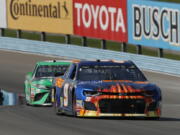 Chase Elliott (9) leads Kyle Busch (18) during a NASCAR Cup series auto race, Sunday, Aug. 5, 2018, in Watkins Glen, N.Y.