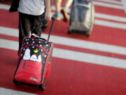 A child pulls a suitcase at Hartsfield-Jackson Atlanta International Airport ahead of the 2017 Thanksgiving holiday. Parents may be feeling pressure to pay more money to sit with their young children on crowded planes.