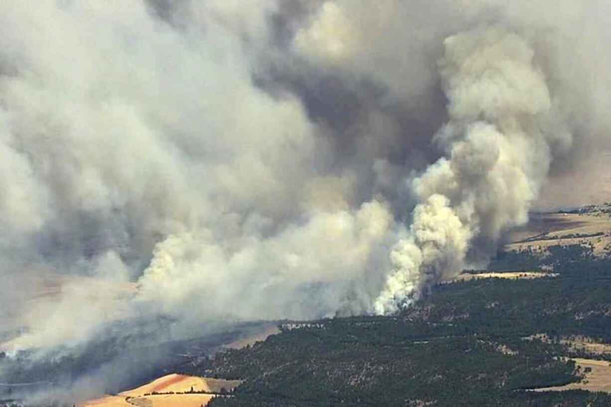 A fast-spreading wildfire moves through Dufur, Ore., on Wednesday. The fire forced mandatory evacuations in the north central Oregon community.