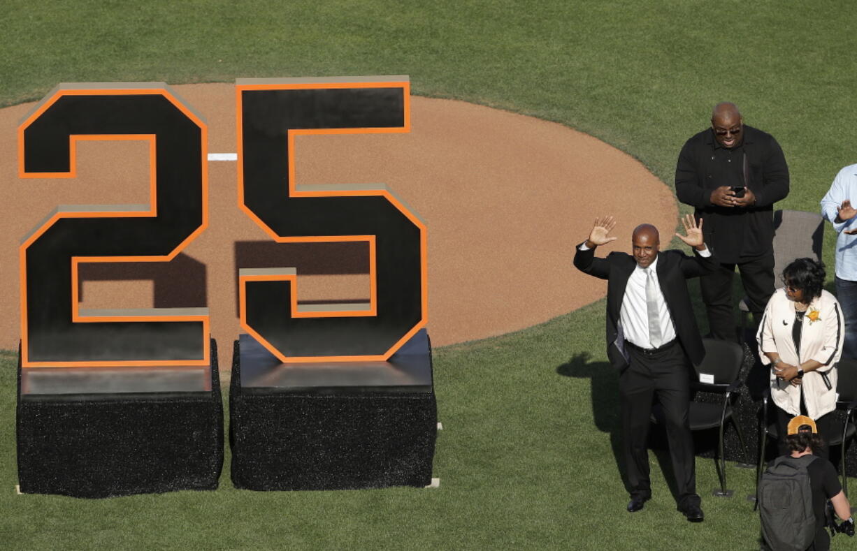 Former San Francisco Giants player Barry Bonds waves to fans next to his mother, Pat, as he is honored during a ceremony to retire his jersey number before a baseball game between the Giants and the Pittsburgh Pirates in San Francisco, Saturday, Aug. 11, 2018.