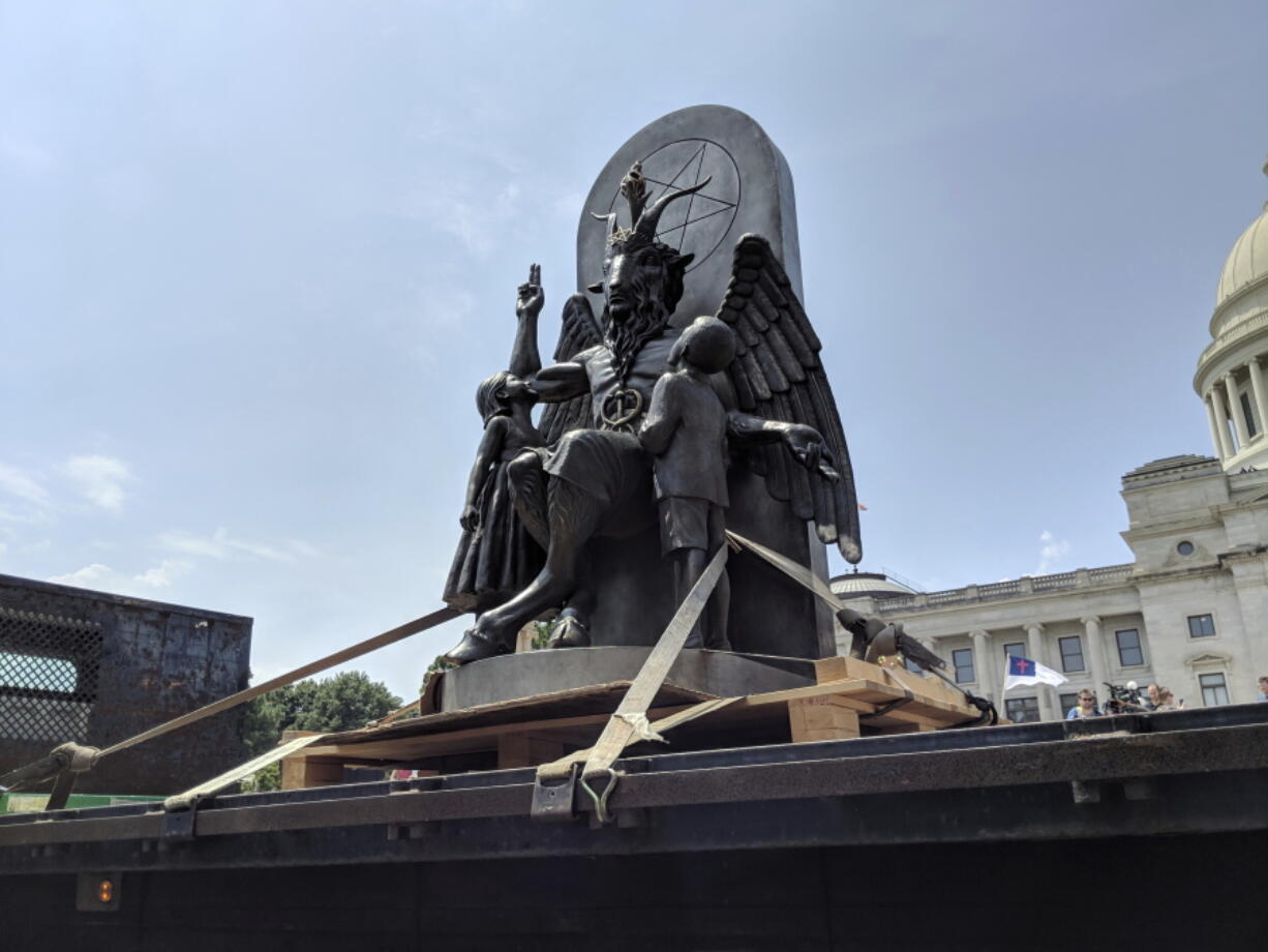 The Satanic Temple unveils its statue of Baphomet, a winged-goat creature, at a rally for the first amendment in Little Rock, Ark., on Thursday. The Satanic Temple wants to install the statue on Capitol grounds as a symbol for religious freedom after a monument of the Biblical Ten Commandments was installed in 2017.