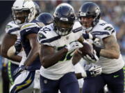 Seattle Seahawks running back Chris Carson (32) runs against the Los Angeles Chargers during the first half.