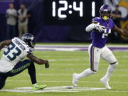 Minnesota Vikings wide receiver Stefon Diggs (14) runs from Seattle Seahawks defensive back Tedric Thompson (33) after making a reception during the first half of an NFL preseason football game, Friday, Aug. 24, 2018, in Minneapolis.