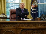 President Donald Trump crosses his arms in the Oval Office of the White House on Monday in Washington.