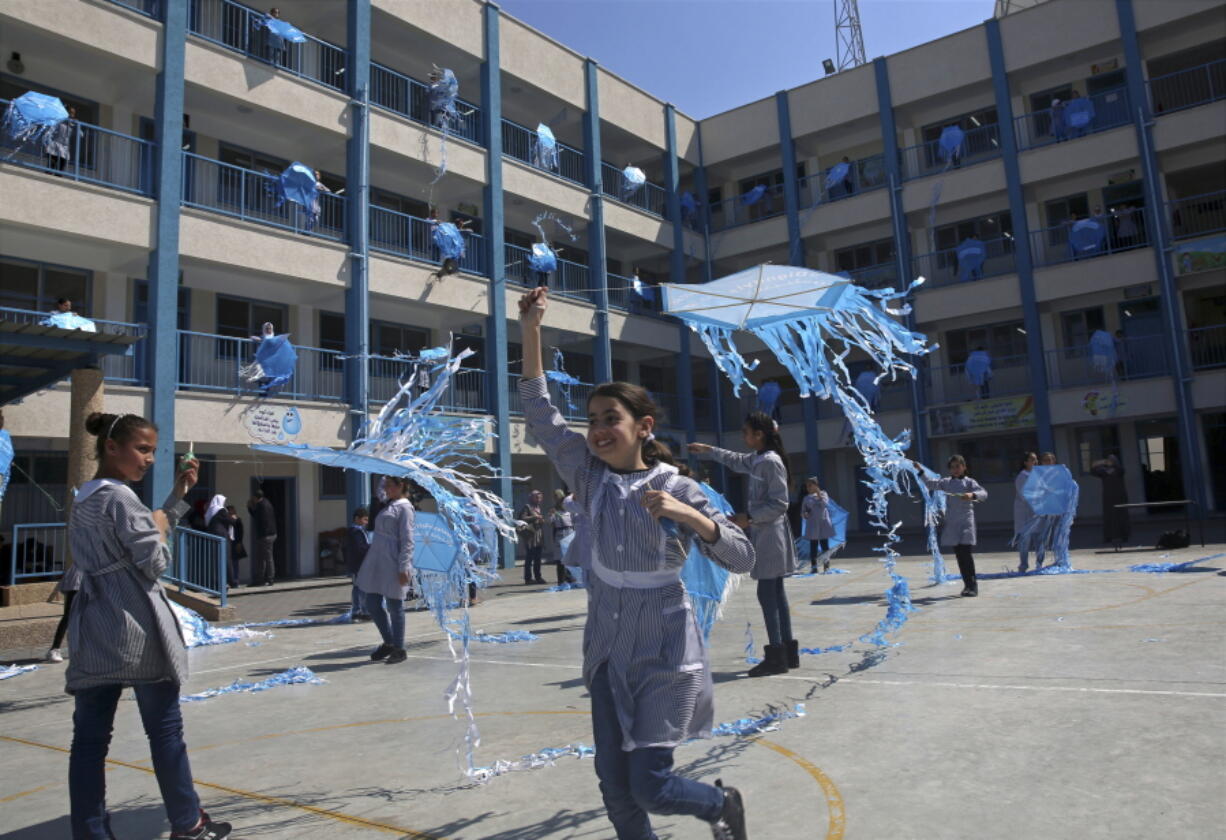 FILE - In this March 12, 2018, file photo, refugee school girls fly kites during the “Kites of Dignity” event at the UNRWA Rimal Girls Preparatory school in Gaza City. The Trump administration has decided to cut more than $200 million in bilateral to the Palestinians, following a review of the funding for projects in the West Bank and Gaza, according to U.S. officials and congressional aides.