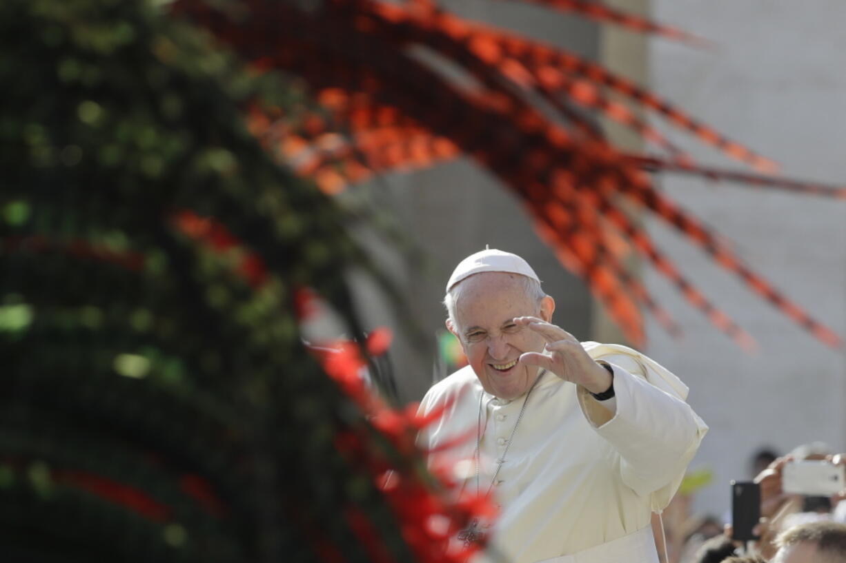 Pope Francis salutes as he arrives for his weekly general audience, at the Vatican on Wednesday.