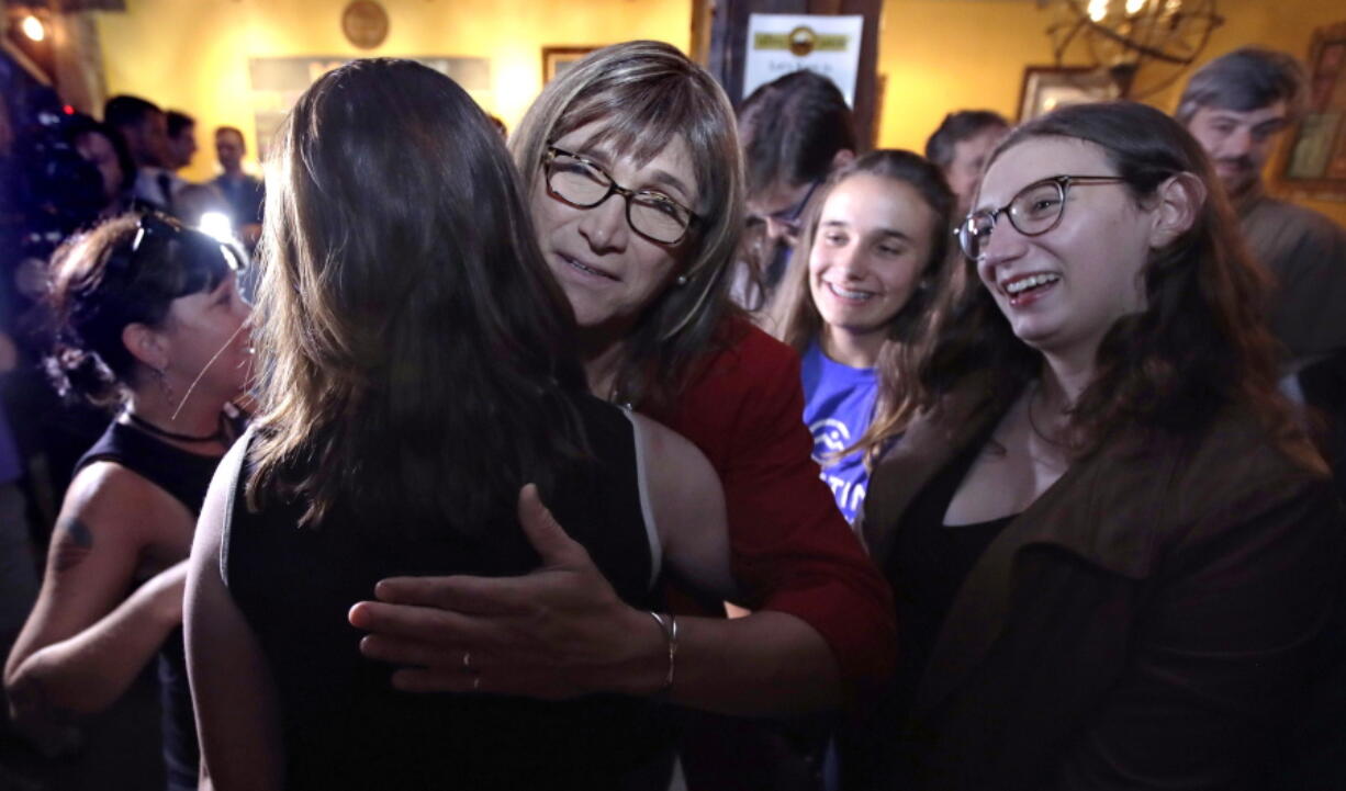 Vermont Democratic gubernatorial candidate Christine Hallquist, center, a transgender woman and former electric company executive, embraces supporters after claiming victory during her election night party in Burlington, Vt., on Tuesday.