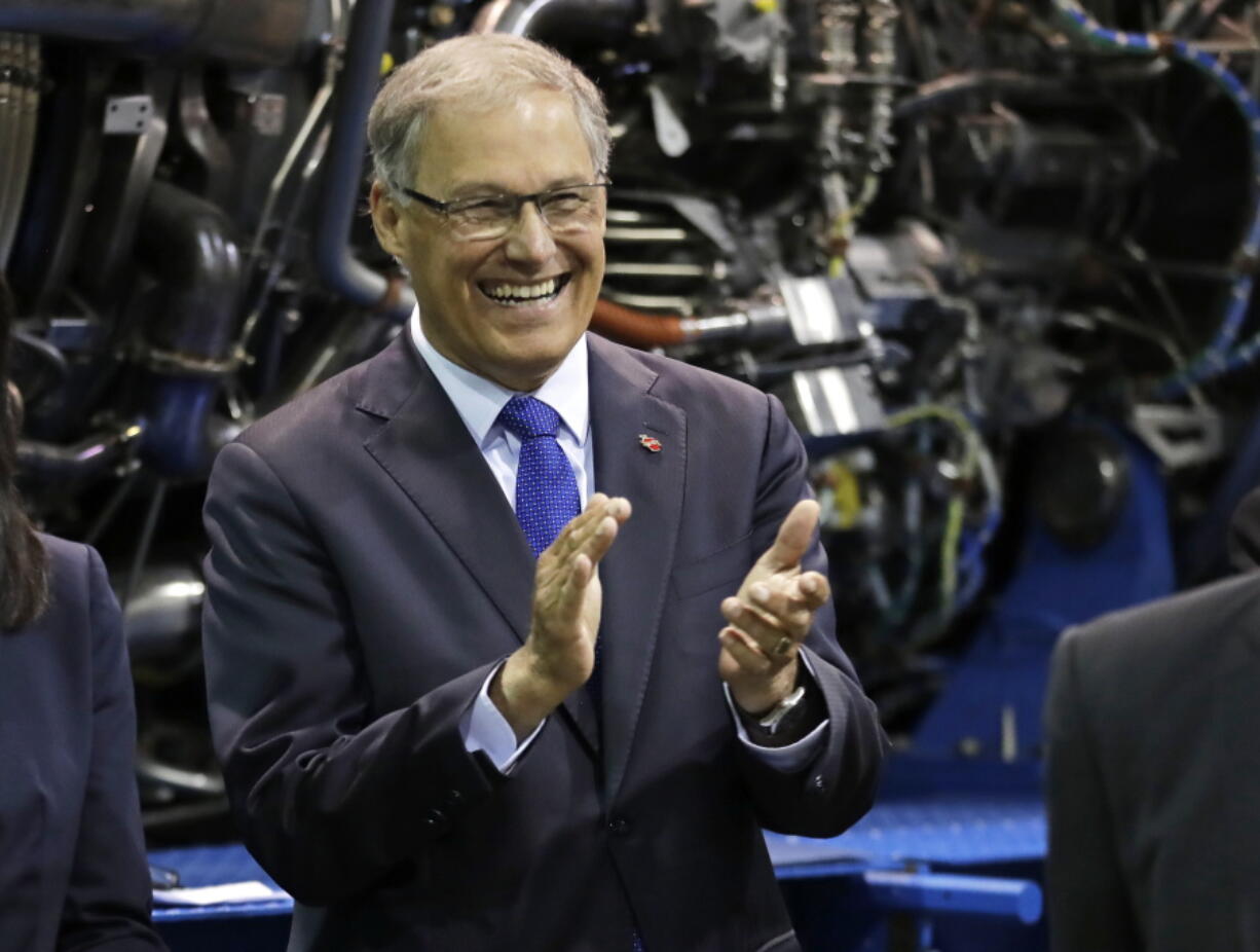 Washington Gov. Jay Inslee applauds as he waits to speak at a news conference in June at South Seattle College in Seattle.