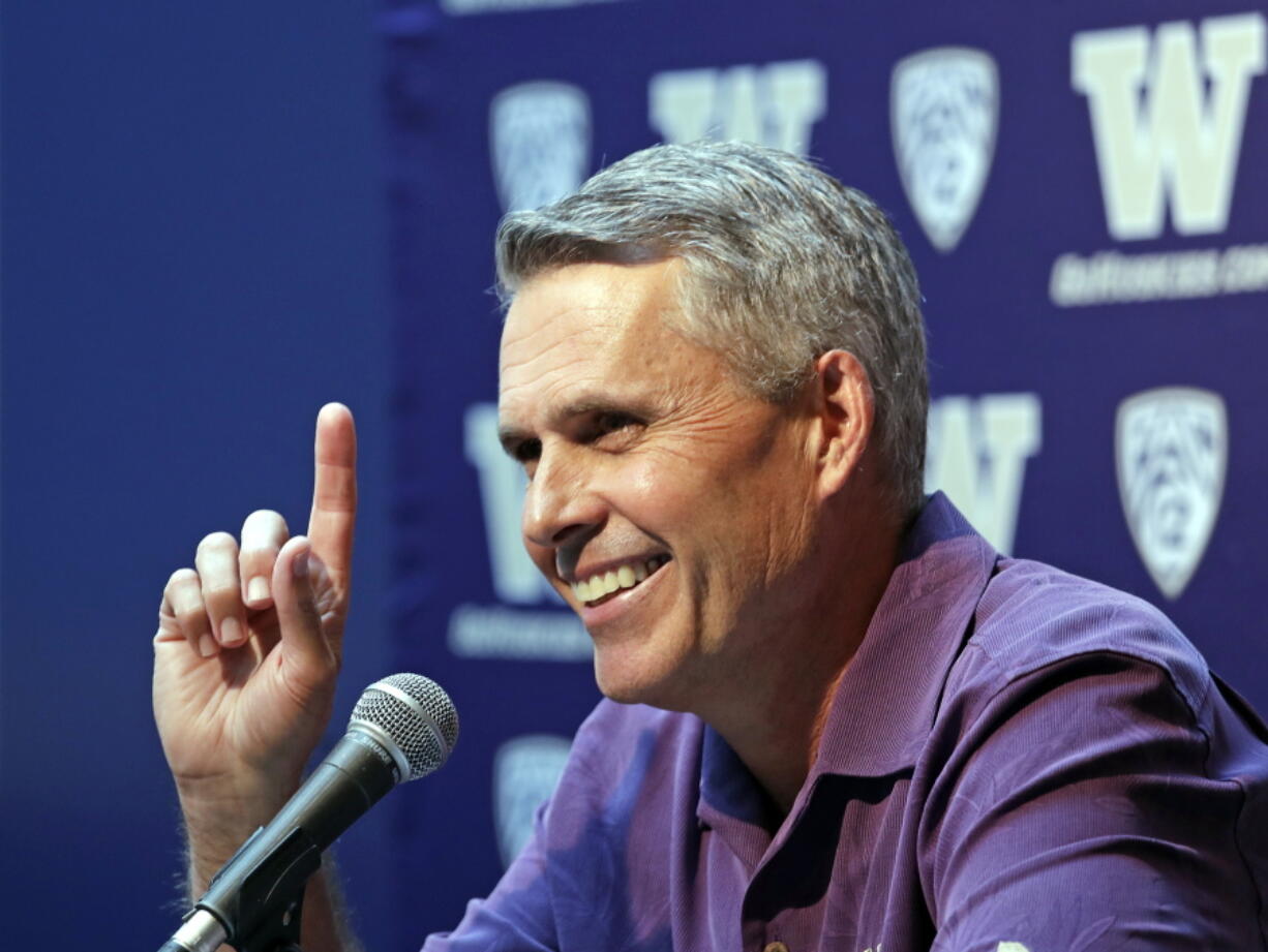 Washington NCAA college head football coach Chris Petersen points skyward in response to hearing Blue Angels jets soar nearby as he speaks at a news conference Thursday, Aug. 2, 2018, in Seattle. Petersen hates expectations, so he’s likely loathing Washington being the overwhelming favorite in the Pac-12 and likely top 10 when the preseason AP poll comes out. The Huskies open fall camp on Friday in preparation for the Sept. 1 opener against Auburn.