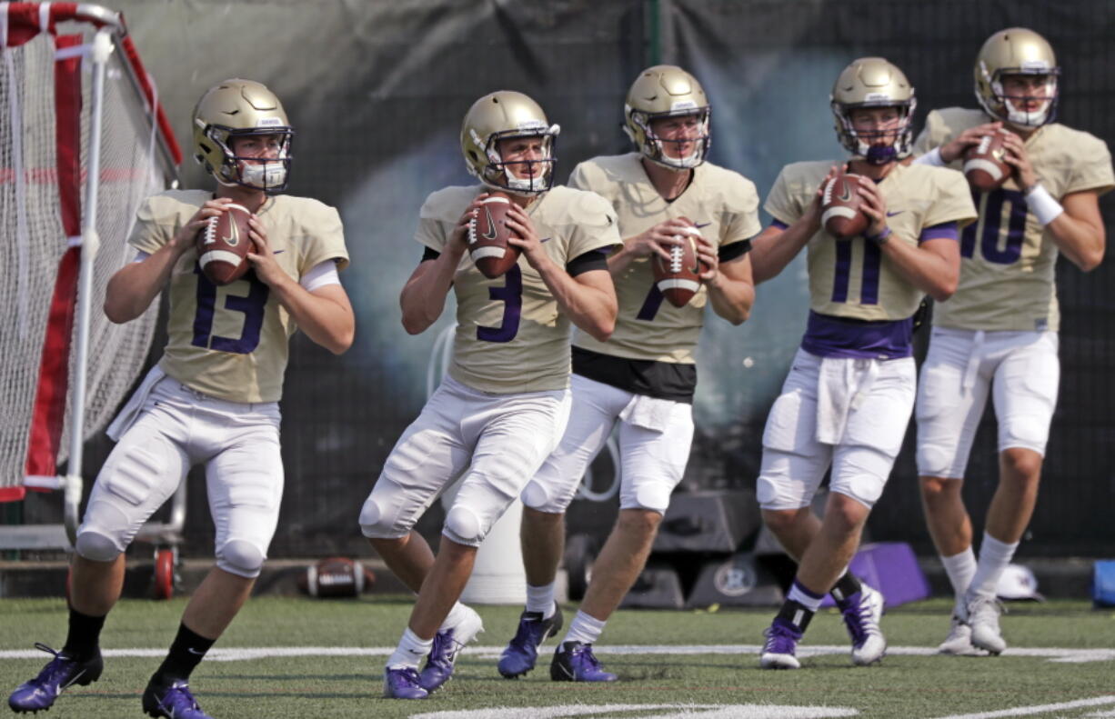 In this photo taken Friday, Aug. 10, 2018, Washington quarterbacks Jake Haener (13), Jake Browning (3), Colson Yankoff (7), Jacob Simon (11) and Jacob Eason (10) line-up to throw during drills at a team football practice in Seattle. For the first time in more than 20 years, Washington will go into a season with a legitimate belief that being in the national championship conversation doesn’t sound foolish. They are the clear choice fin the Pac-12 North and to win the Pac-12 title. Accomplish both of those and there’s a good chance the Huskies could find themselves in the College Football Playoff for the second time in three years.