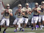 In this photo taken Friday, Aug. 10, 2018, Washington quarterbacks Jake Haener (13), Jake Browning (3), Colson Yankoff (7), Jacob Simon (11) and Jacob Eason (10) line-up to throw during drills at a team football practice in Seattle. For the first time in more than 20 years, Washington will go into a season with a legitimate belief that being in the national championship conversation doesn’t sound foolish. They are the clear choice fin the Pac-12 North and to win the Pac-12 title. Accomplish both of those and there’s a good chance the Huskies could find themselves in the College Football Playoff for the second time in three years.