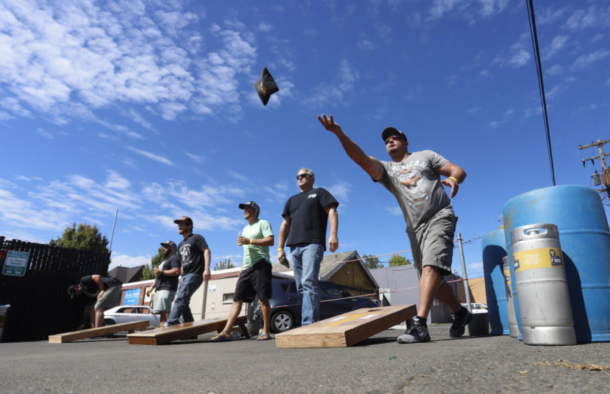 Shawn McKay, right, of Ghost Runners Brewery and Rod Edwards of Shoug Brewing compete with their fellow independent craft brewers at the Brewers Invitational Cornhole Tournament at Trap Door Brewing Sunday. The event was part of Northbank Beer Week, which runs through Saturday.