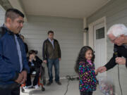 Reynaldo Ojeda, left, watches as Evergreen Habitat for Humanity’s Bruce Armstrong hands keys to Ojeda’s family’s new house to his daughter 6-year-old daughter, Leslie, Sunday afternoon.