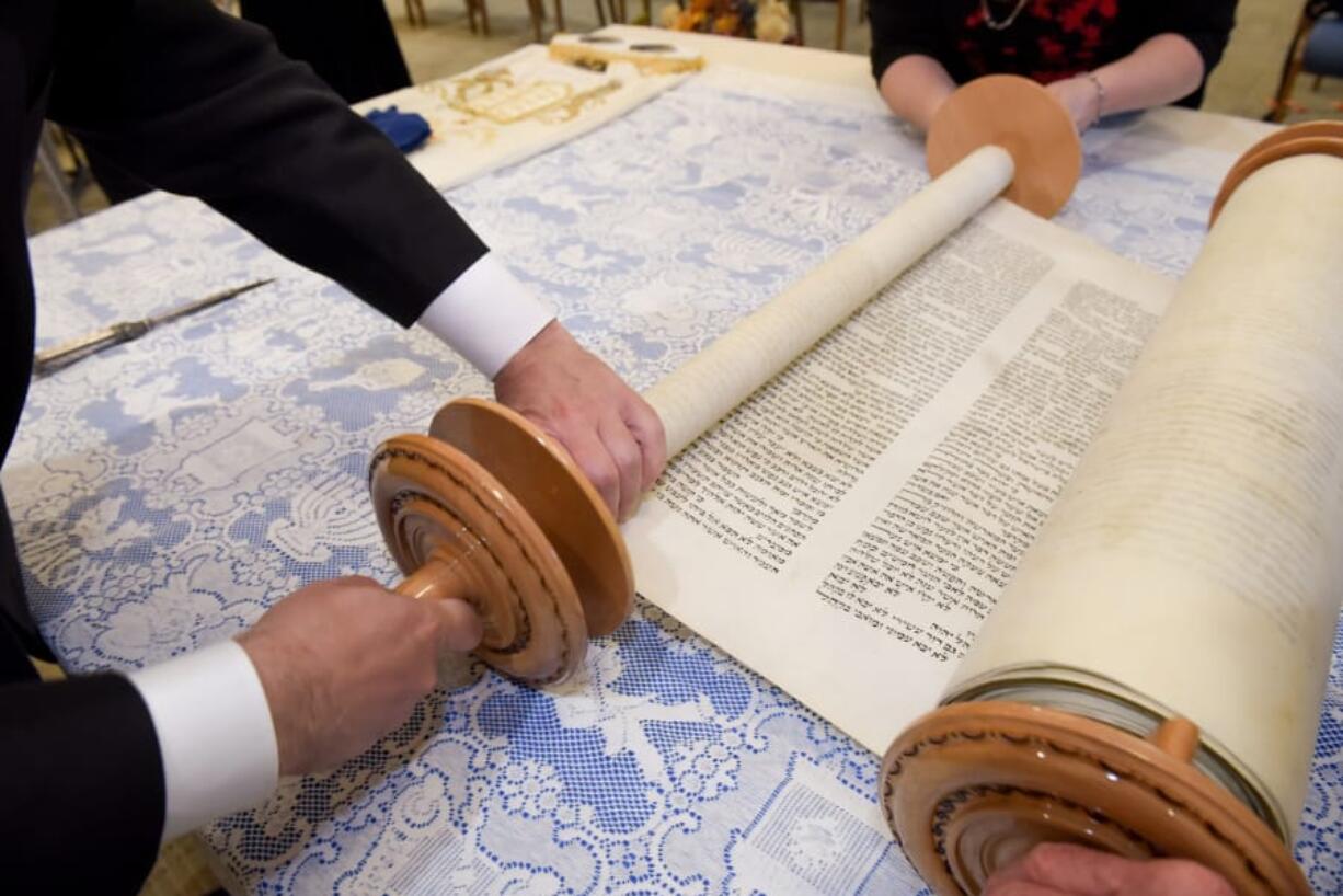 Congregation Am Chai’s Torah, loaned to the synagogue from its late Rabbi who rescued it from concentration camp survivors in Poland after World War II, is readied Sept. 9 for the High Holidays held at St. Raymond de Penafort Catholic Church in Mt. Prospect, Ill.