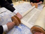 Congregation Am Chai’s Torah, loaned to the synagogue from its late Rabbi who rescued it from concentration camp survivors in Poland after World War II, is readied Sept. 9 for the High Holidays held at St. Raymond de Penafort Catholic Church in Mt. Prospect, Ill.