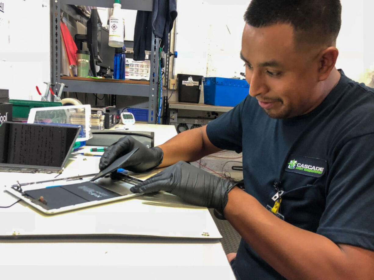 Isauro Flores-Hernandez takes apart used smartphones and tablets for a living at Cascade Asset Management, an electronics scrap processor in Madison, Wis. Geoffrey A.