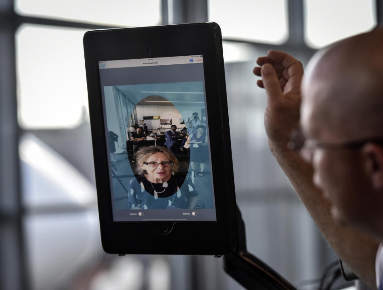 Station manager Chad Shane of SAS Airlines takes a traveler through the scanning process at Dulles International Airport. The facial scans can be compared with stored passport and visa photos.