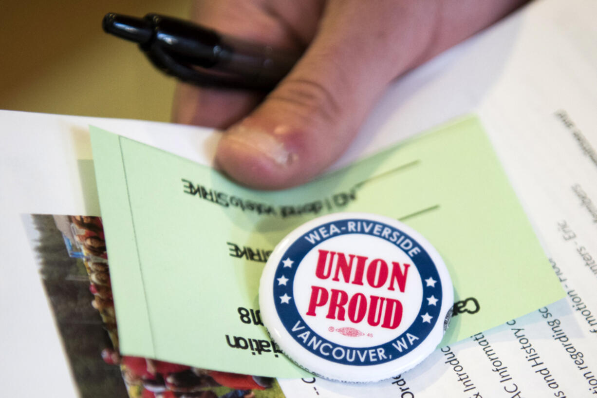 Teachers sign in a pick up their voting materials before the Camas Education Association general membership meeting on Aug. 2at Camas High School.