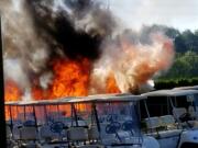 A fire burns brush and near golf carts at Club Green Meadows Tuesday afternoon.