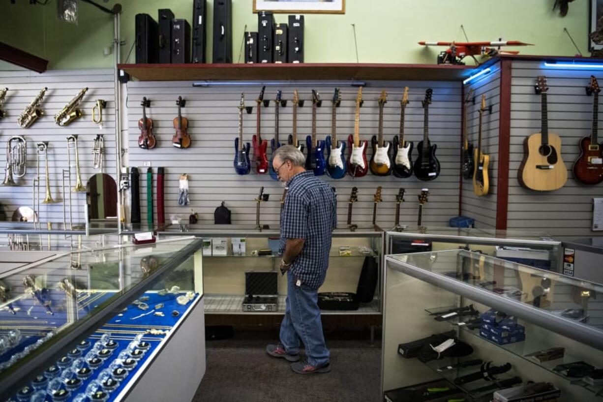 Randy Meeks of Winston-Salem, N.C., browses the cases at Cameo Main Street Loan and Pawn Shop in downtown Vancouver on Wednesday. After more than six decades in business, Cameo Main Street will close its doors in November. The shop has planned a weekend auction on Nov. 17 and 18 to sell the remaining inventory.