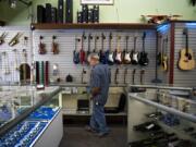 Randy Meeks of Winston-Salem, N.C., browses the cases at Cameo Main Street Loan and Pawn Shop in downtown Vancouver on Wednesday. After more than six decades in business, Cameo Main Street will close its doors in November. The shop has planned a weekend auction on Nov. 17 and 18 to sell the remaining inventory.