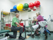 Woodland Care Center physical therapist Jim Ferris, 79, left, works with Barbara, who preferred to not give her last name, on her range of motion and strength while walking on her prosthetic leg. Ferris is part of a growing number among seniors to continue working later in life.