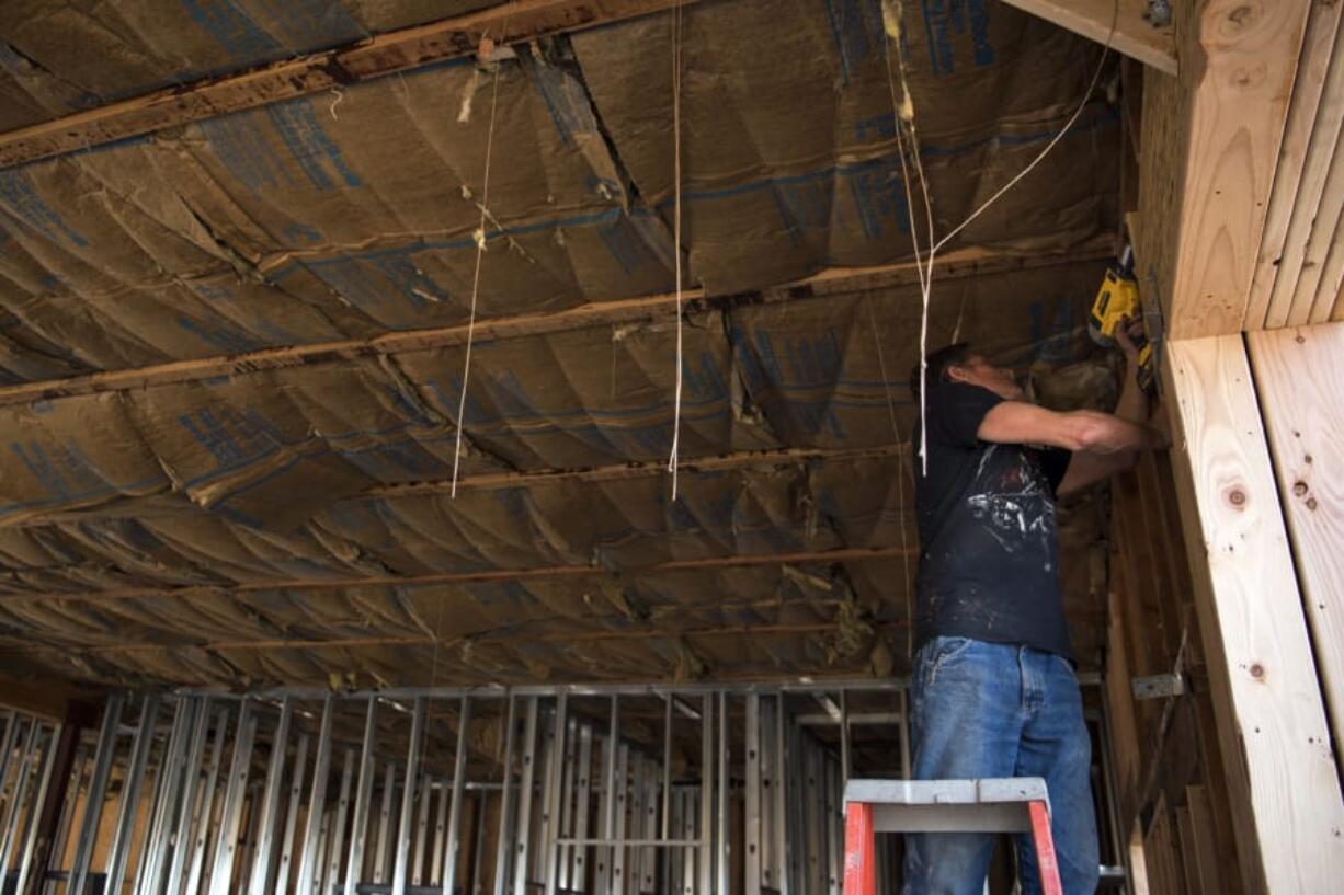 Randy Rogers of Vancouver works on the framing of entrance doors at the site of the old Namaste Indian Cuisine building in Vancouver in August. Clark County has seen a 12.2 percent increase in construction jobs in in 2018 over 2017.