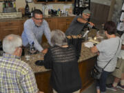 Owner Dave Kelly, behind the counter left of Bob Mayfield, serve customers wine at Windy Hills Winery in Ridgefield Sunday. The winery was a stop on the weekend’s wine and appetizer pairing events hosted by several local wineries.