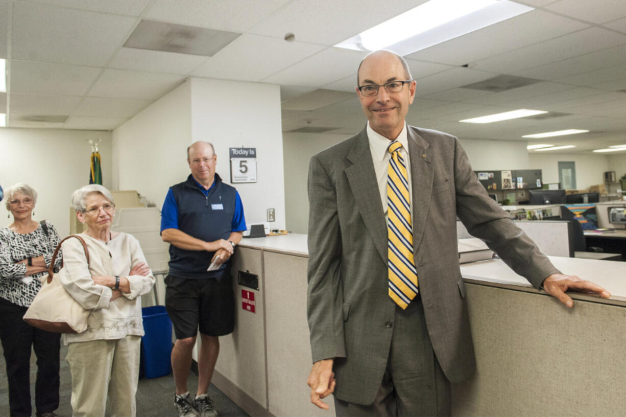 Clark County Auditor Greg Kimsey, right, watches the quarter fall during a coin flip Wednesday morning in the Elections Office to determine the winner of Precinct Committee Officer 692.