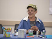 Linda Harbaugh chats with art class participants at NAMI. Harbaugh has made acrylic and water color paintings, masks, prints and other projects in the class.