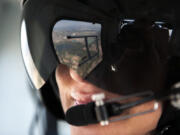 The view is reflected in the visor of flight nurse Michelle LaVina during a demonstration flight in September.