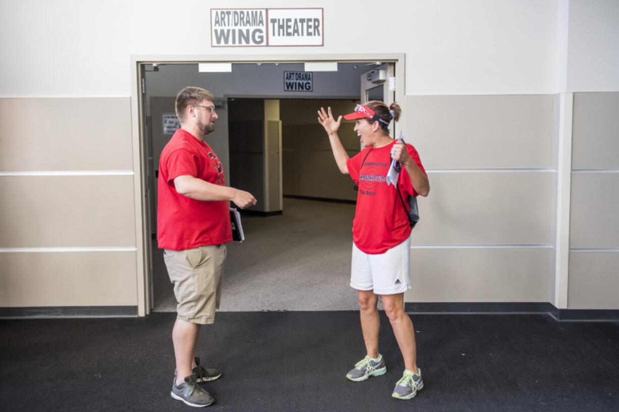 Cory Marshall, Camas High School teacher, left, and Alisa Wise, Camas High School math teacher, react following the Camas Education Association’s unanimous vote to ratify a new salary schedule for teachers. The vote allows school to start on time in Camas, and avoids a teacher strike.