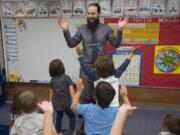 Kindergarten teacher Micah Wolfe sings a song with students during the first day of class at Peter S. Ogden Elementary School on Wednesday morning. Teachers are back in the classroom after three days on strike and four days of school cancellations.