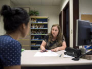 Connie Brown, a clerk in the Clark County Facilitator’s Office, right, helps Divine Cochran of Vancouver figure out paperwork and steps she needs to take in her divorce.