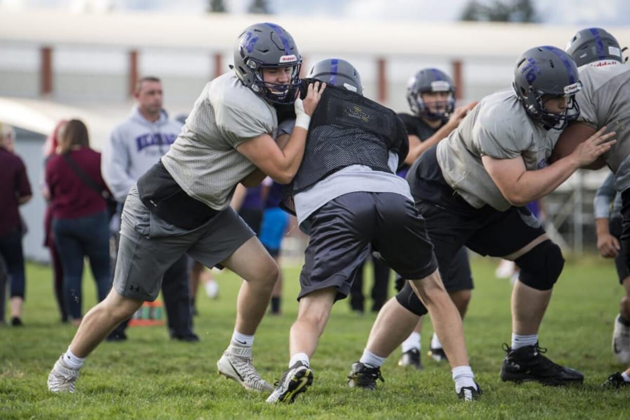 Heritage senior Andrew Thom, left, worked his way up from an undersized tight end to an all-league player who plays on offense and defense for the Timberwolves.