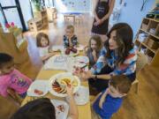 Tzivie Greenberg, right, director of The Gan Garrett Jewish Preschool, serves up apples and honey to children celebrating Rosh Hashanah, the Jewish New Year, a couple of days early. It will be year 5779, according to the Jewish calendar.