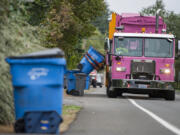 A Waste Connections driver collects curbside recycling bins from a Vancouver neighborhood.