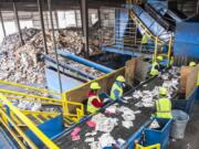 Line sorters comb through plastics and paper moving along a conveyor belt at Waste Connections Washington-Clark County material recycling facility on Northwest Lower River Road. The site processes tens of thousands of tons of recyclable materials every year, mostly from Clark County.