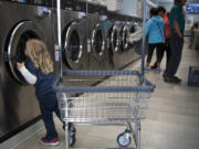 Leo Guerra, 3, peeks in the washer before helping his parents unload laundry at Cedars Laundromat in Woodland on Sept. 11, when the laundromat was hosting its monthly Laundry Love event where people can do laundry for free. The national program was brought to Woodland in April by DeeAnna Holland.