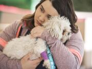 Veterinarian Assistant Rose Islam comforts Fritzy during his exam during the free pet clinic at Open House Ministries on Thursday afternoon, Sept. 20, 2018.