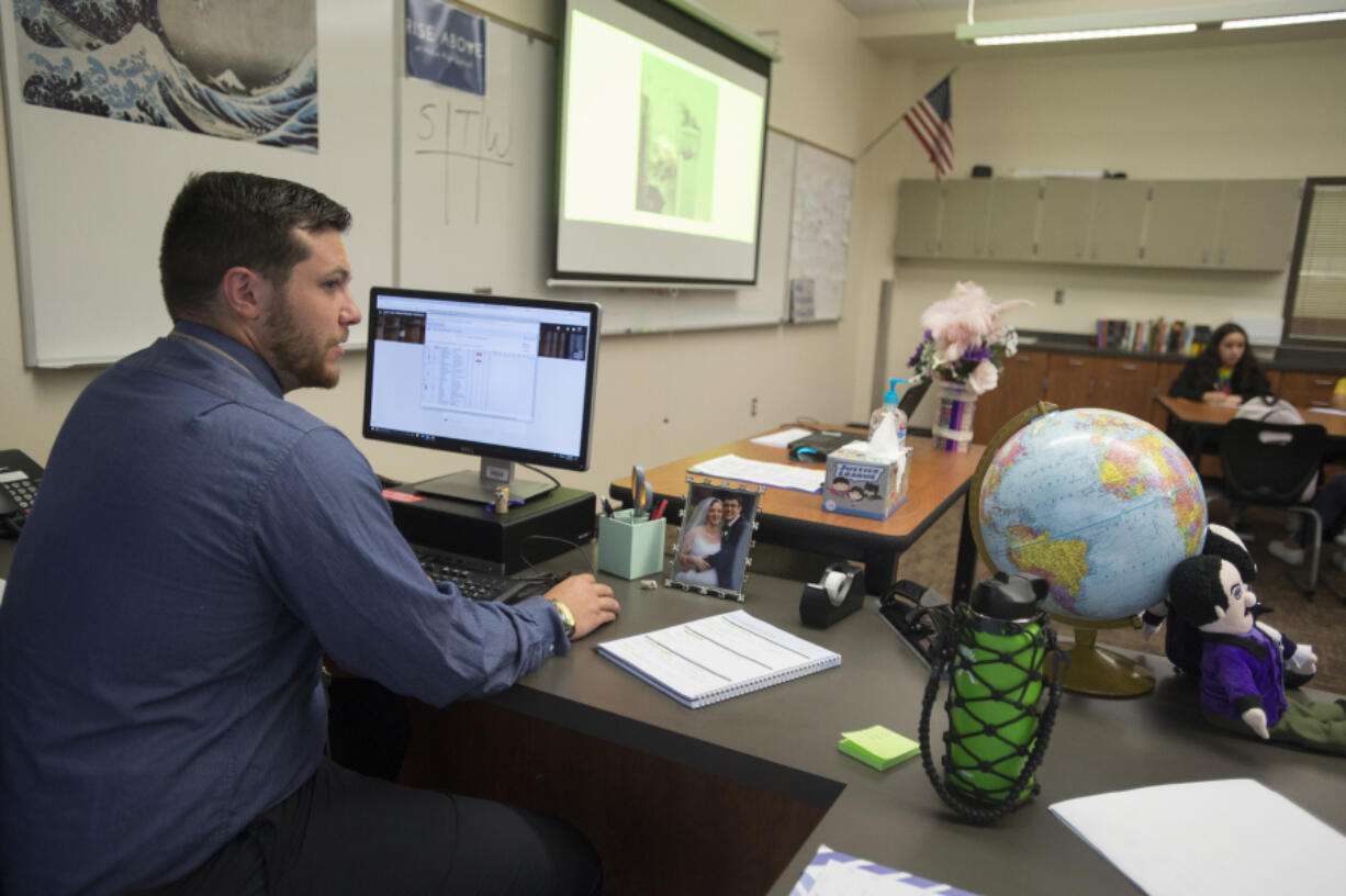 Teacher Jack Thompson goes through the attendance list for freshmen on the first day of school at Henrietta Lacks Health and Bioscience High School on Monday morning. This is Thompson’s first year in the classroom. He said he formed bonds with his fellow teachers on the picket lines these past two weeks.