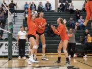 Ridgefield's Kameryn Reynolds (9), Alicia Andrew (7) and Delaney Nicoll (3) celebrate a point during their game in Woodland on Tuesday, Sept. 11, 2018. Ridgefield defeated Woodland in three sets, 25-16, 25-22, 25-17.