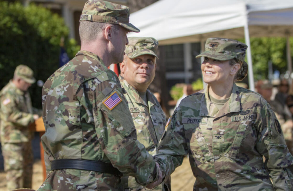 Col. Heather A. Reuter, right, the new commander of the 2nd Brigade, 95th Division of the U.S. Army Reserve, shakes hands with Brig. Gen. R. Andrew Bassford, left, the commanding general of the 95th Division, after delivering remarks during the unit’s changing of the guard ceremony Sunday at Fort Vancouver. Reuter formally assumed command from Col. Thomas Olsen, center, during the ceremony, which included military traditions, such as an inspection and review of soldiers and the passing of the organizational colors. Photo contributed by U.S. Army Sgt.