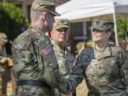 Col. Heather A. Reuter, right, the new commander of the 2nd Brigade, 95th Division of the U.S. Army Reserve, shakes hands with Brig. Gen. R. Andrew Bassford, left, the commanding general of the 95th Division, after delivering remarks during the unit’s changing of the guard ceremony Sunday at Fort Vancouver. Reuter formally assumed command from Col. Thomas Olsen, center, during the ceremony, which included military traditions, such as an inspection and review of soldiers and the passing of the organizational colors. Photo contributed by U.S. Army Sgt.