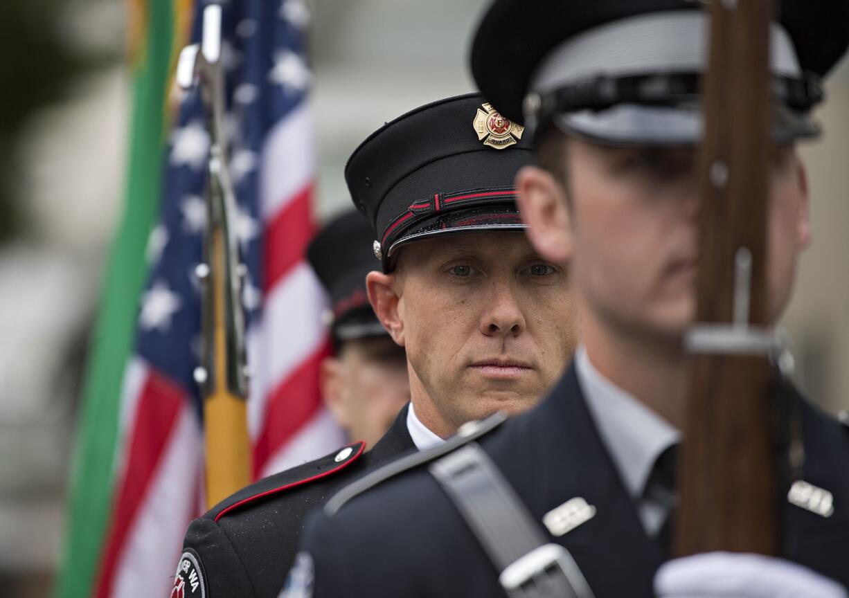 Capt. Tyler Dillmon joins members of the Vancouver Fire Department and Vancouver Police Department honor guard in a quiet moment before posting the colors during the annual Sept. 11, 2001 remembrance outside City Hall on Tuesday morning, Sept. 11, 2018.