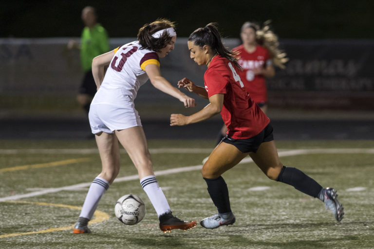 Prairie's Savannah Harshbarger (3) tries to stop Camas' Maddie Kemp (4) as Kemp drives downfield toward the goal during Tuesday night's game at Doc Harris Stadium in Camas on Sept. 18, 2018. Camas won 10-3.