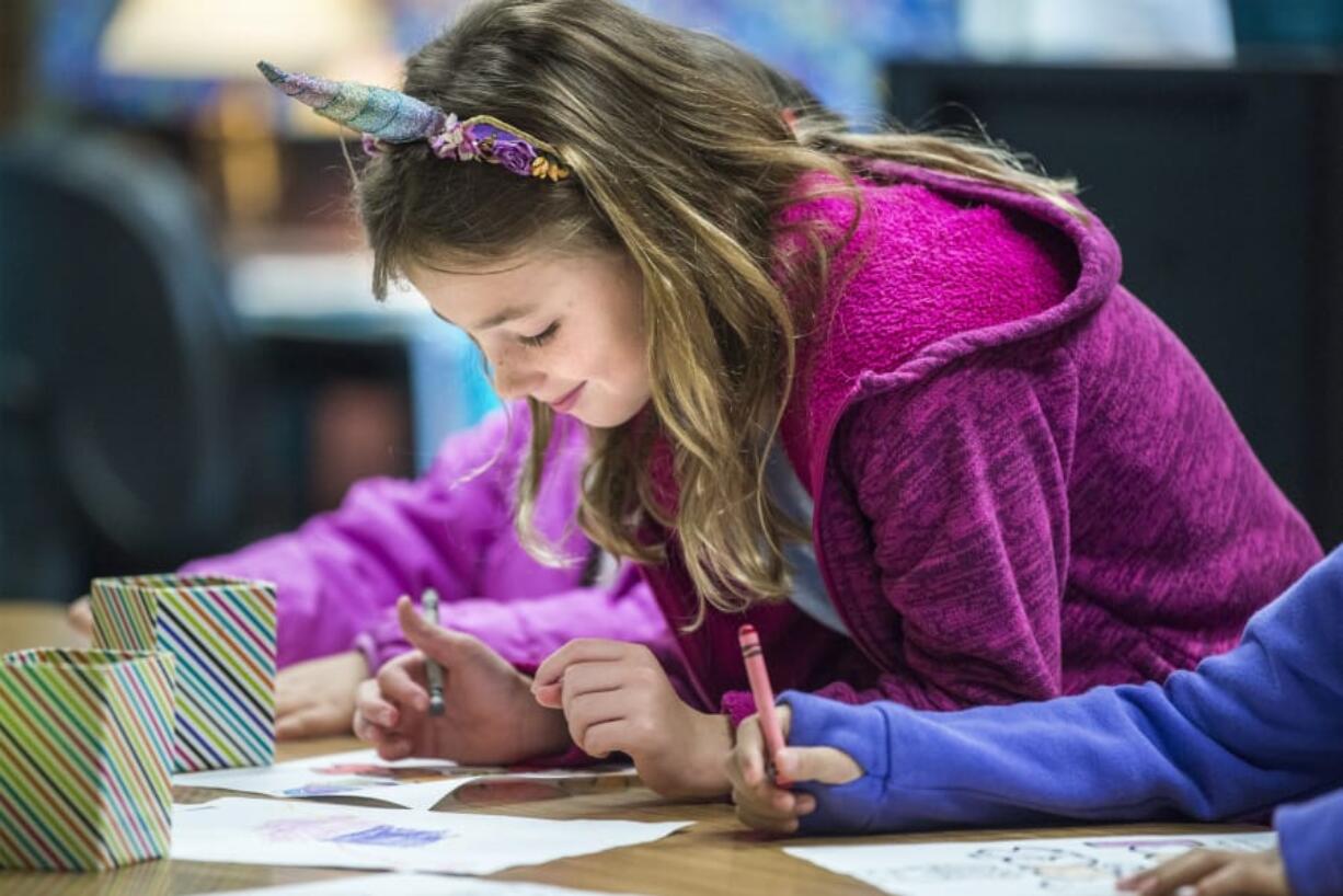 Second-grader Samantha Covel colors a picture on her first day of school at Pleasant Valley Primary School on Monday morning.