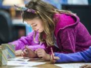 Second-grader Samantha Covel colors a picture on her first day of school at Pleasant Valley Primary School on Monday morning.